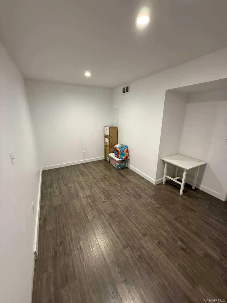 Empty room with recessed lighting and dark wood-style floors Empty room with recessed lighting and dark wood-style floors