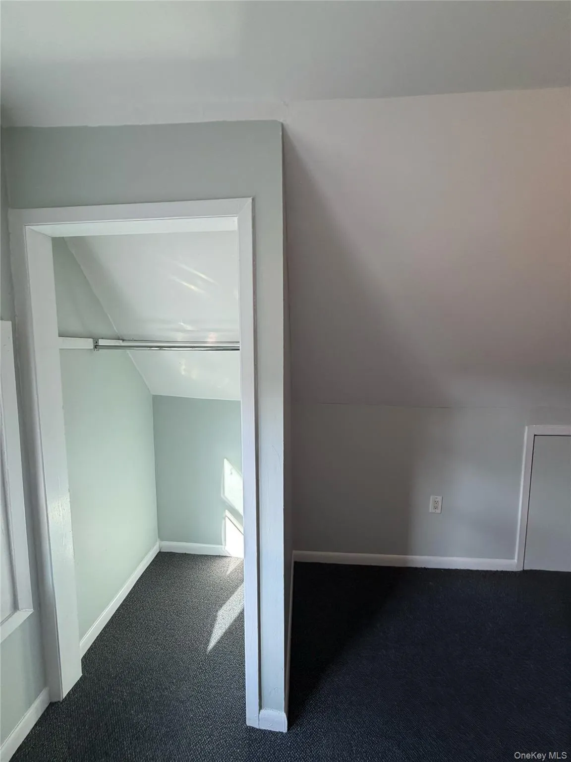 Additional living space featuring dark colored carpet and lofted ceiling Additional living space featuring dark colored carpet and lofted ceiling