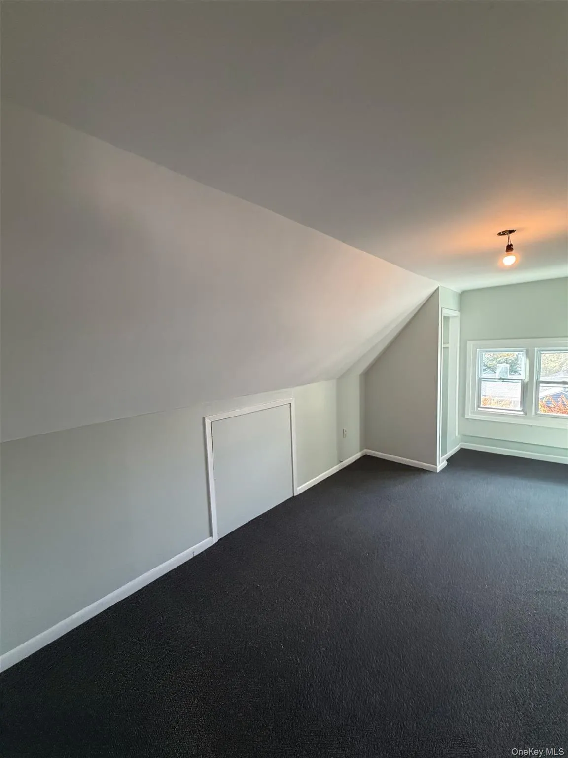 Additional living space with lofted ceiling and dark carpet Additional living space with lofted ceiling and dark carpet