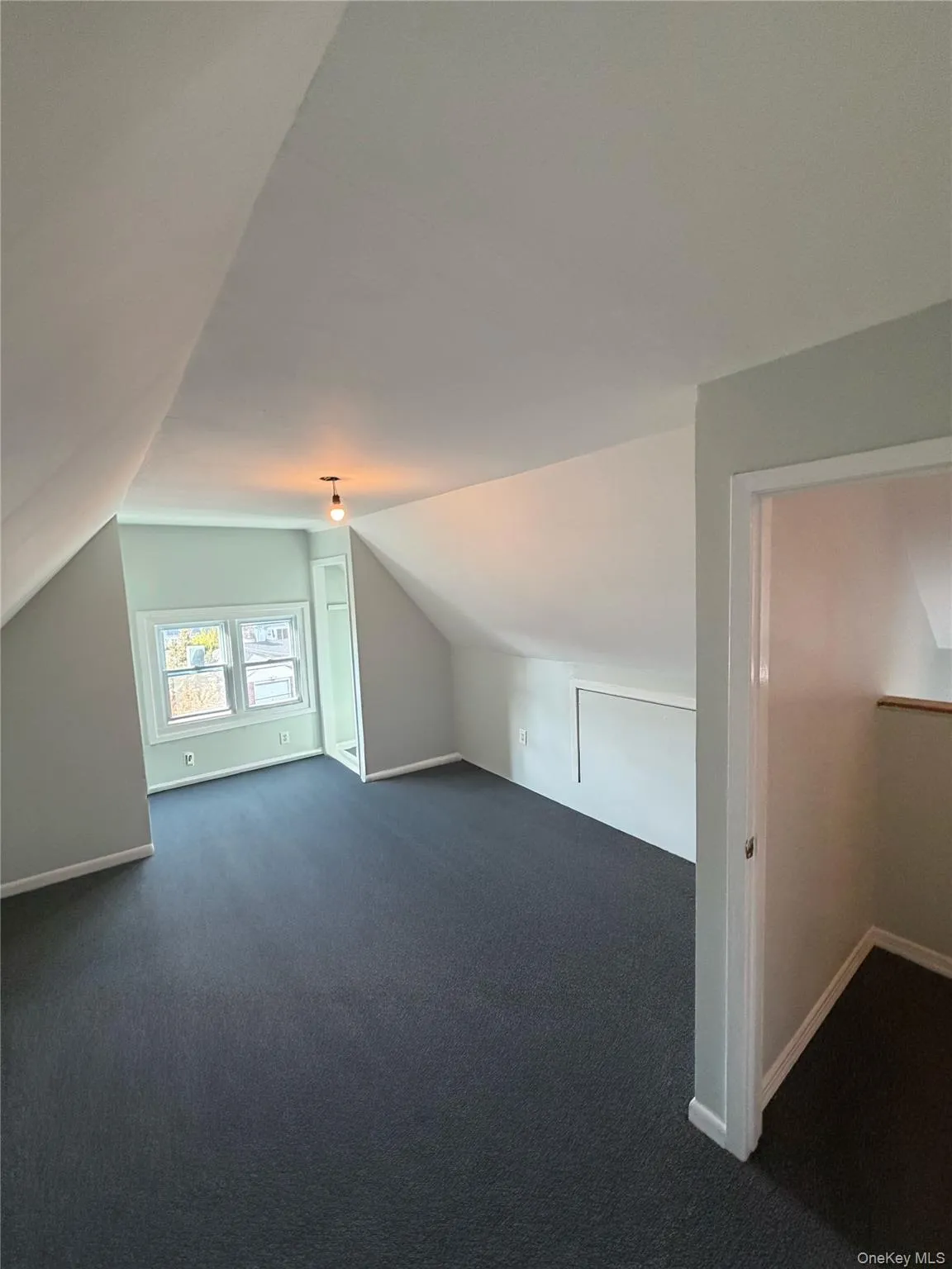 Bonus room featuring vaulted ceiling and dark carpet Bonus room featuring vaulted ceiling and dark carpet