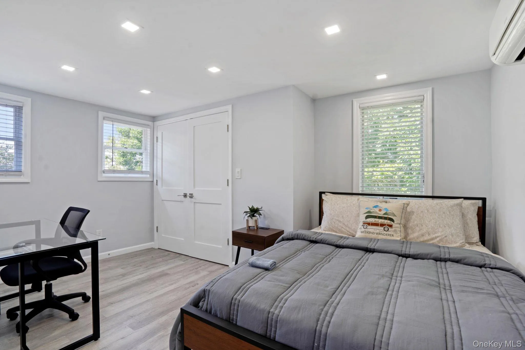 Bedroom with wood finished floors, a wall unit AC, an office area, recessed lighting, and a closet Bedroom with wood finished floors, a wall unit AC, an office area, recessed lighting, and a closet
