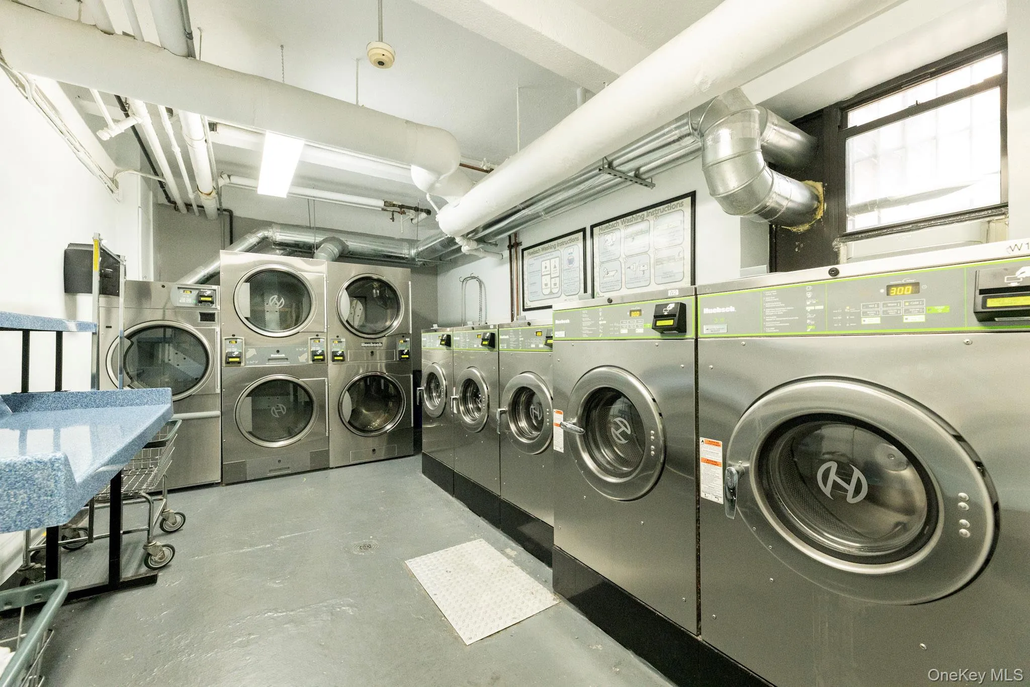 Shared laundry room with stacked washing machine and dryer and washer and clothes dryer Shared laundry room with stacked washing machine and dryer and washer and clothes dryer