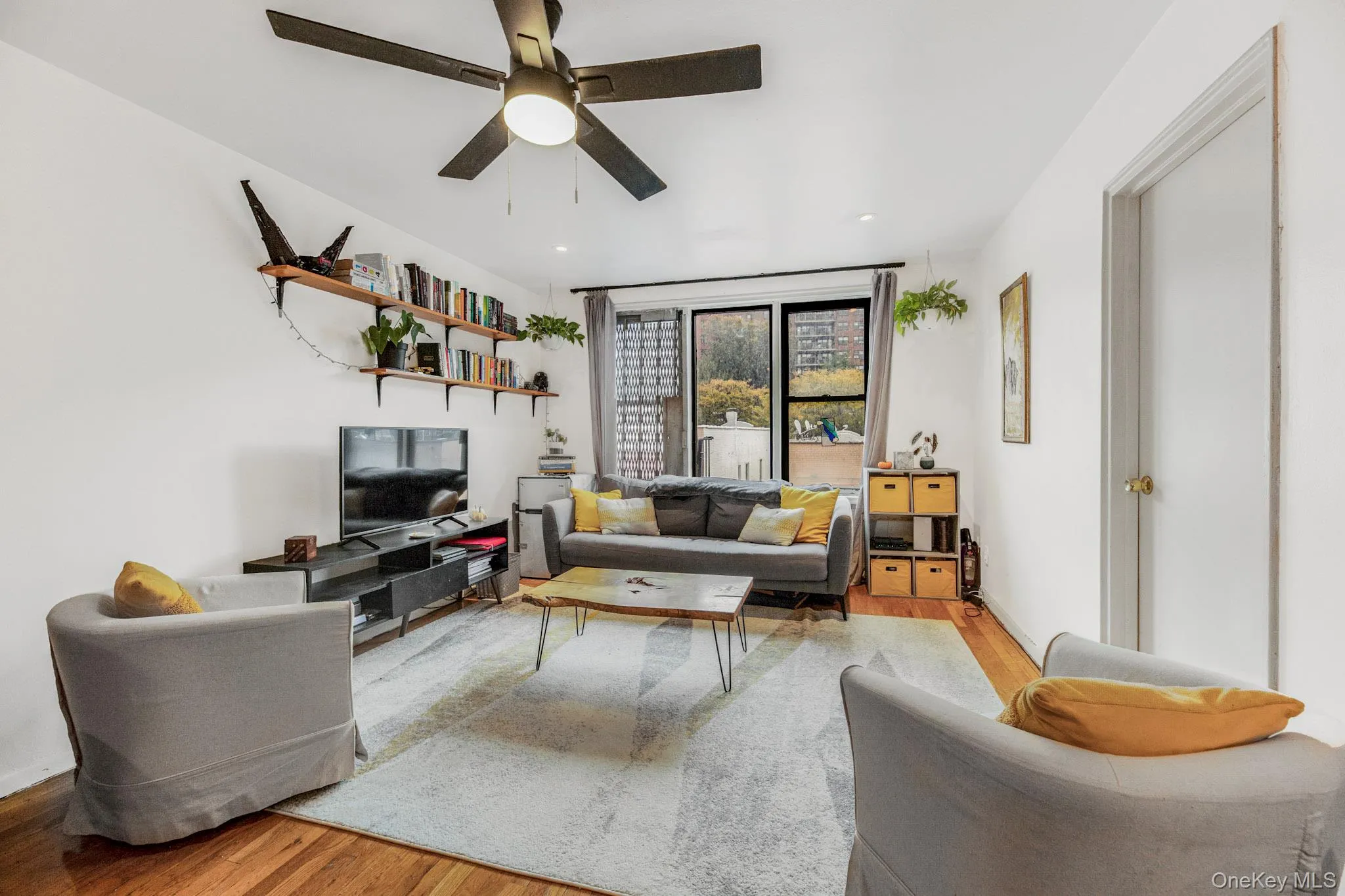 Living room with wood finished floors and a ceiling fan Living room with wood finished floors and a ceiling fan
