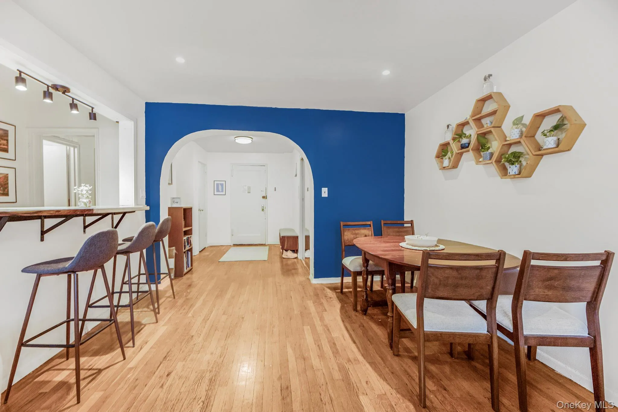 Dining area with light wood-style floors, arched walkways, and recessed lighting Dining area with light wood-style floors, arched walkways, and recessed lighting
