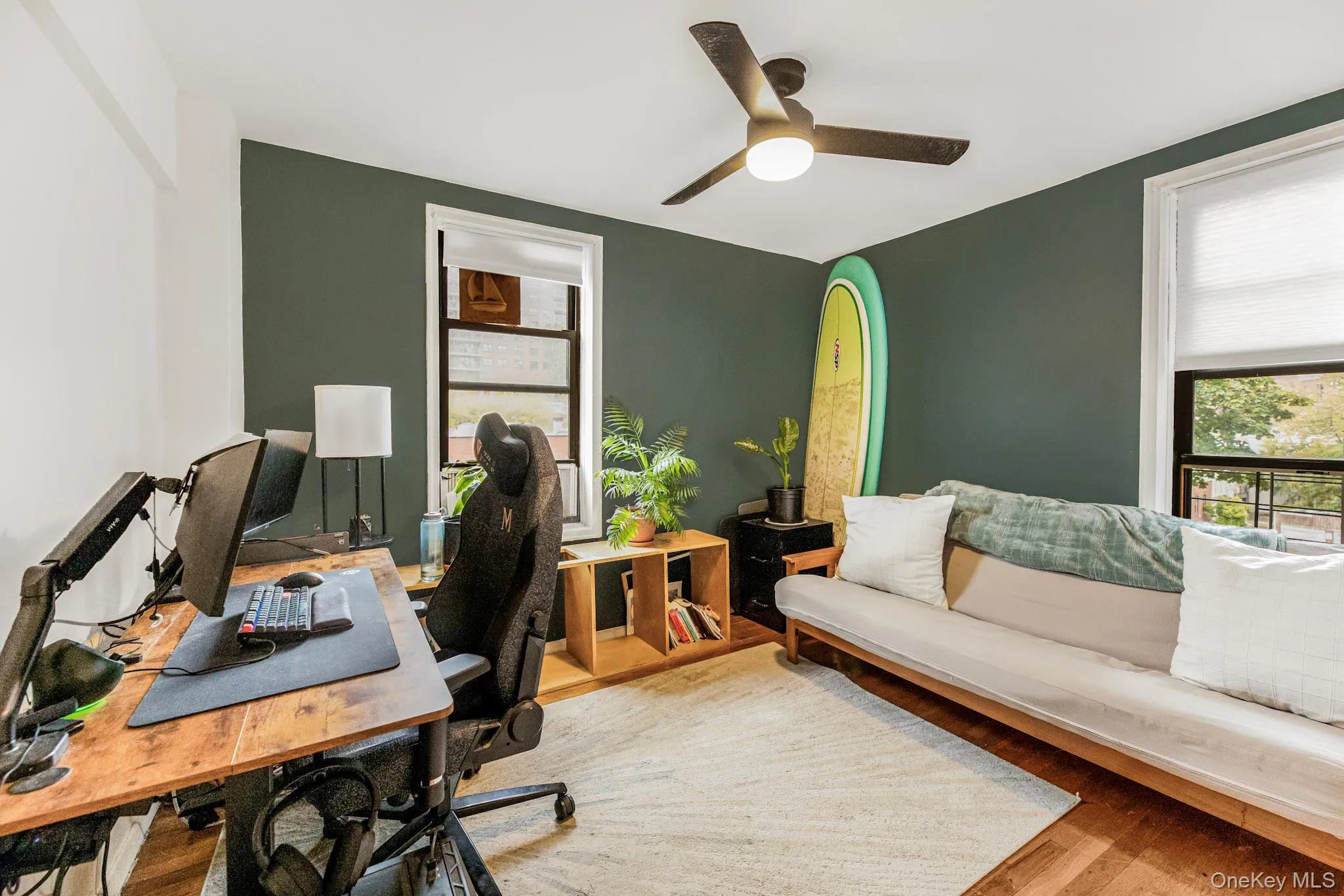 Office space with wood finished floors, plenty of natural light, and a ceiling fan Office space with wood finished floors, plenty of natural light, and a ceiling fan