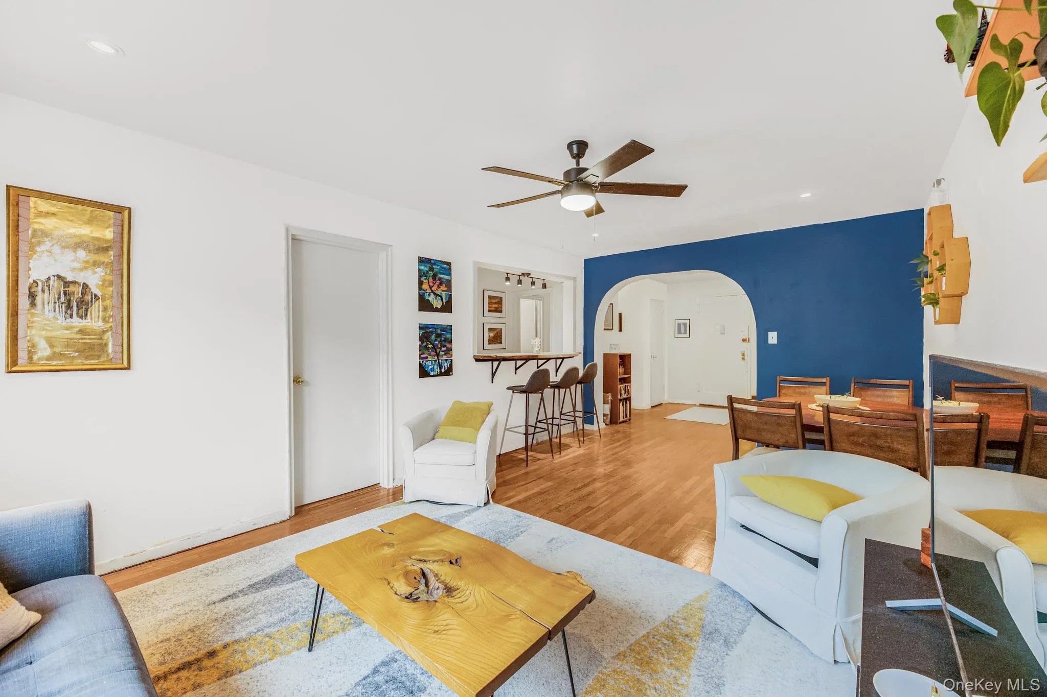 Living area featuring wood finished floors, recessed lighting, arched walkways, and a ceiling fan Living area featuring wood finished floors, recessed lighting, arched walkways, and a ceiling fan