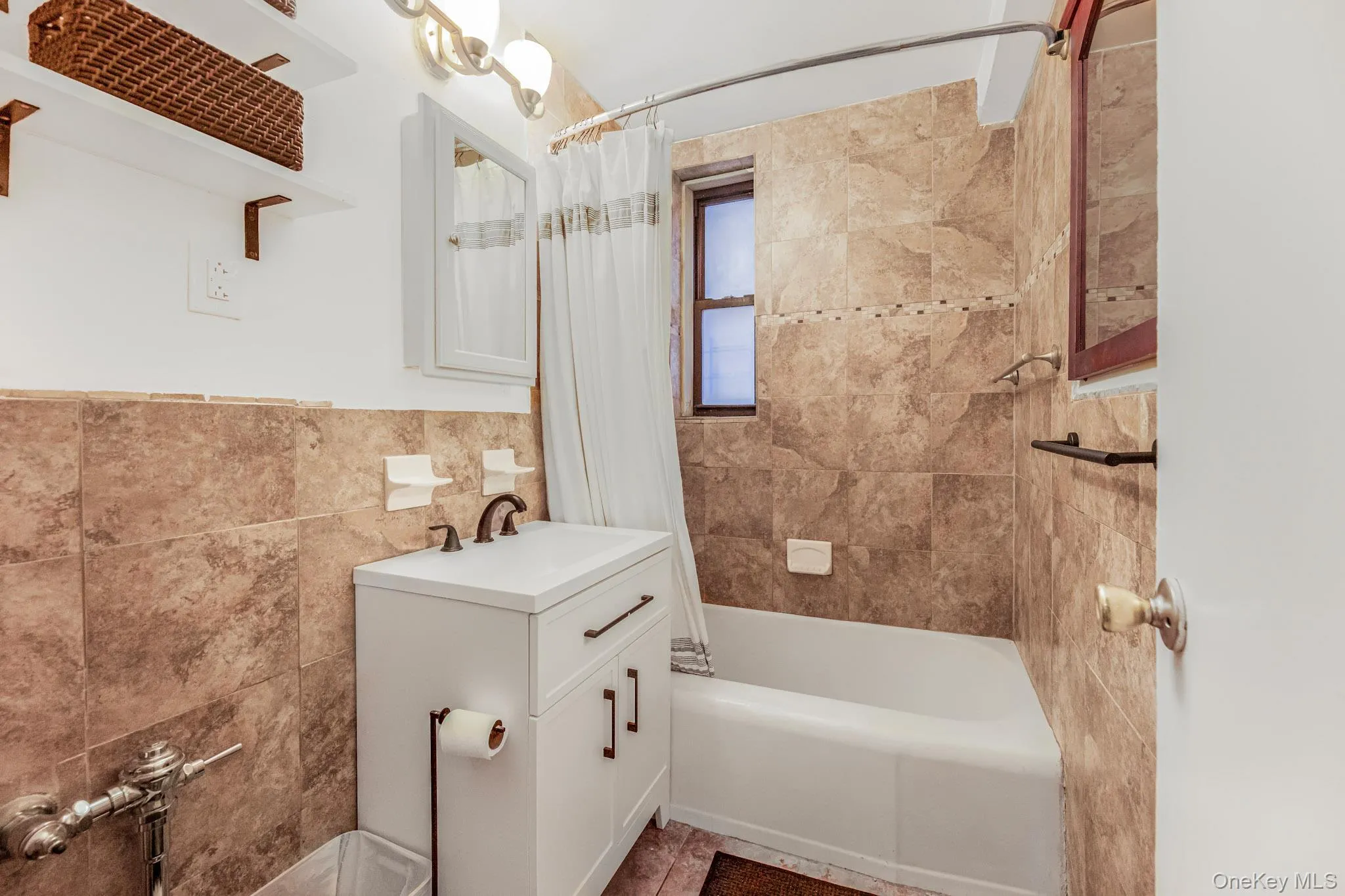 Bathroom with vanity, tile walls, and shower / tub combo with curtain Bathroom with vanity, tile walls, and shower / tub combo with curtain