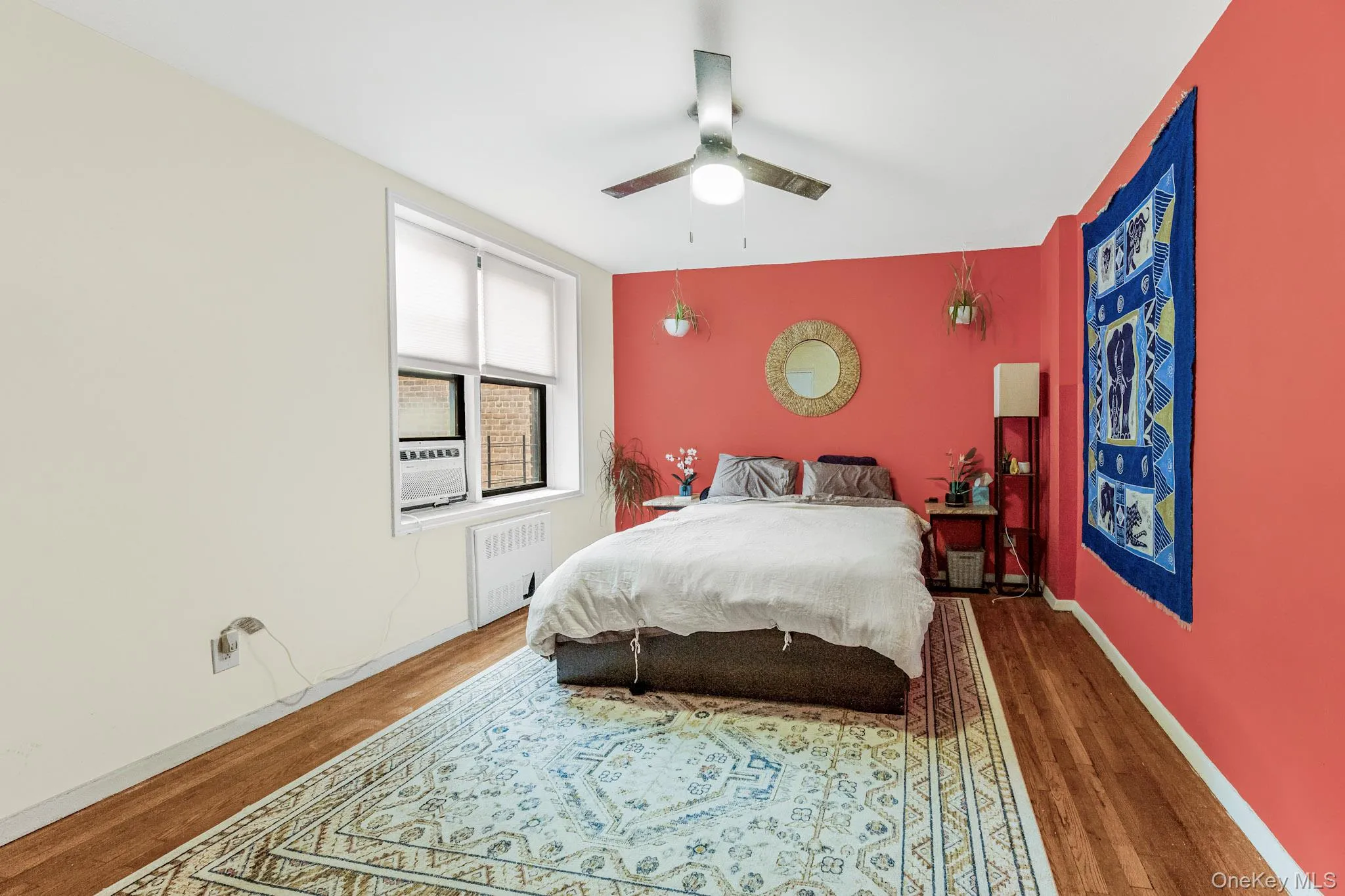 Bedroom with radiator, wood finished floors, and ceiling fan Bedroom with radiator, wood finished floors, and ceiling fan