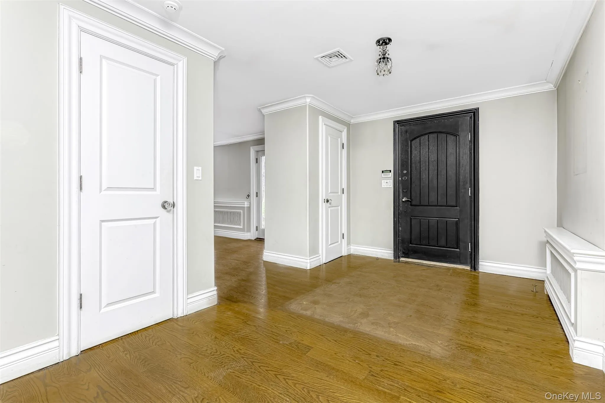 Foyer with wood finished floors and crown molding Foyer with wood finished floors and crown molding