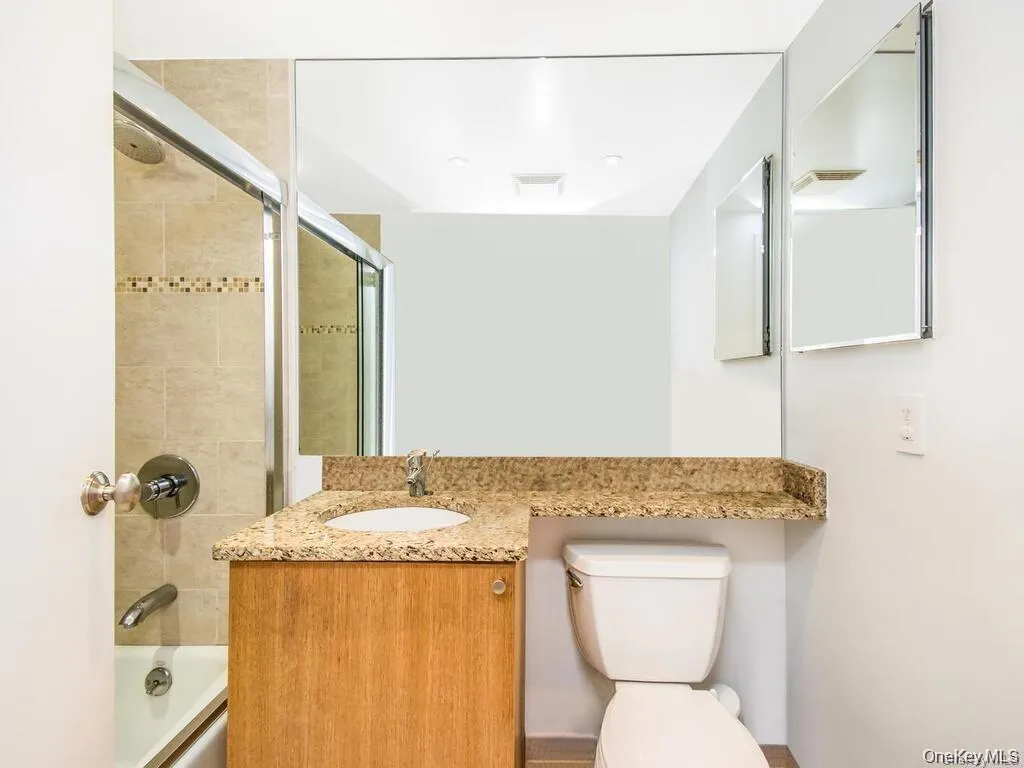 Full bath with combined bath / shower with glass door and vanity Full bath with combined bath / shower with glass door and vanity