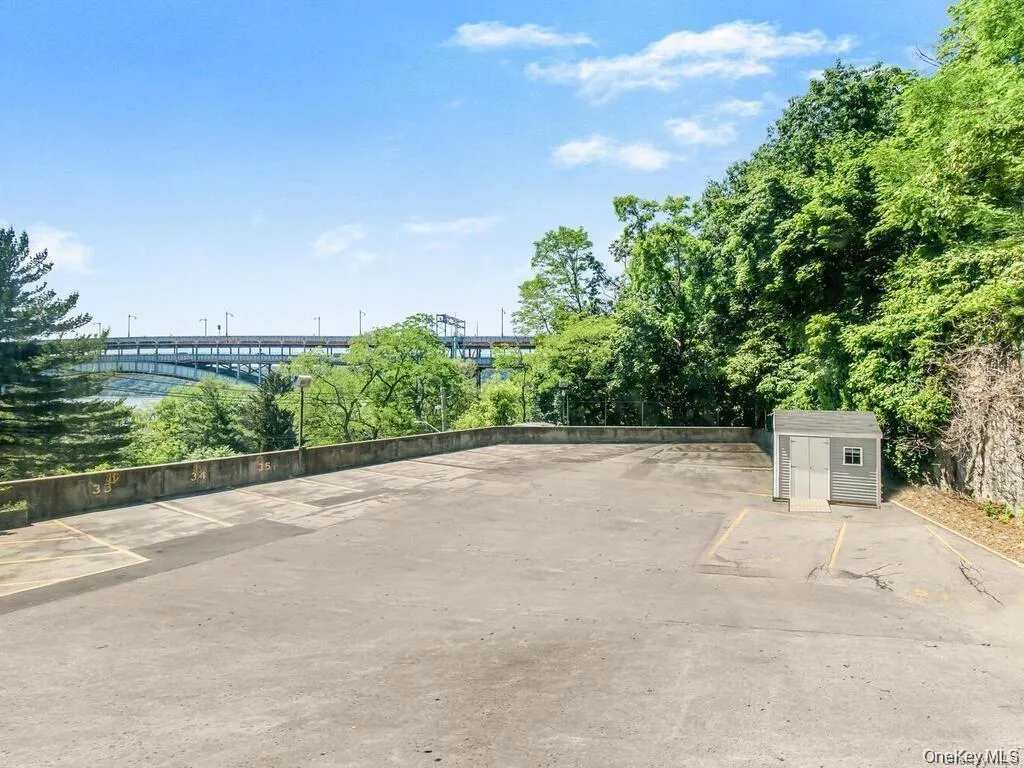 Uncovered parking lot featuring a storage shed Uncovered parking lot featuring a storage shed