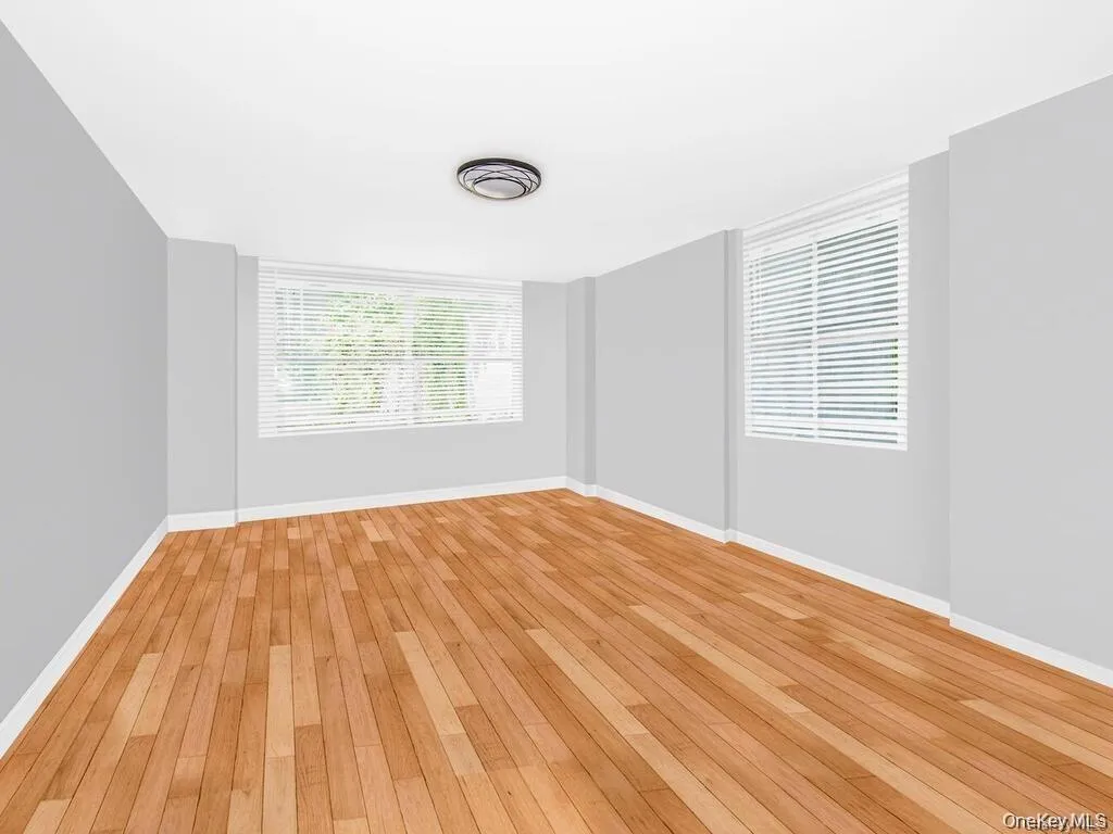Unfurnished room with light wood finished floors and baseboards Unfurnished room with light wood finished floors and baseboards