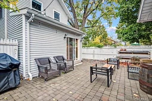 Fenced backyard featuring a patio area, grilling area, and an outdoor living space Fenced backyard featuring a patio area, grilling area, and an outdoor living space