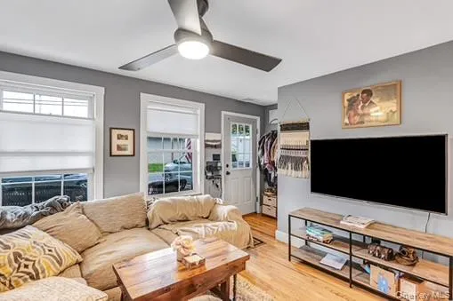 Living area featuring wood finished floors and a ceiling fan Living area featuring wood finished floors and a ceiling fan