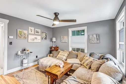 Living area featuring wood finished floors and ceiling fan Living area featuring wood finished floors and ceiling fan