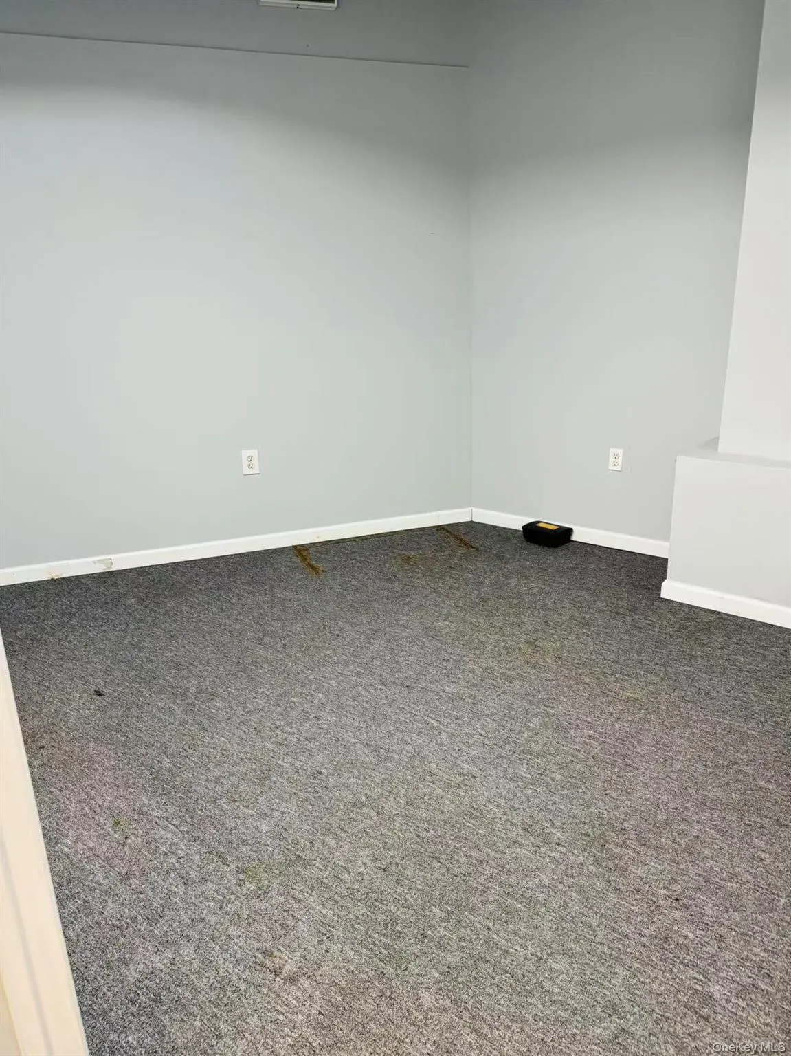 Empty room featuring baseboards and dark carpet Empty room featuring baseboards and dark carpet