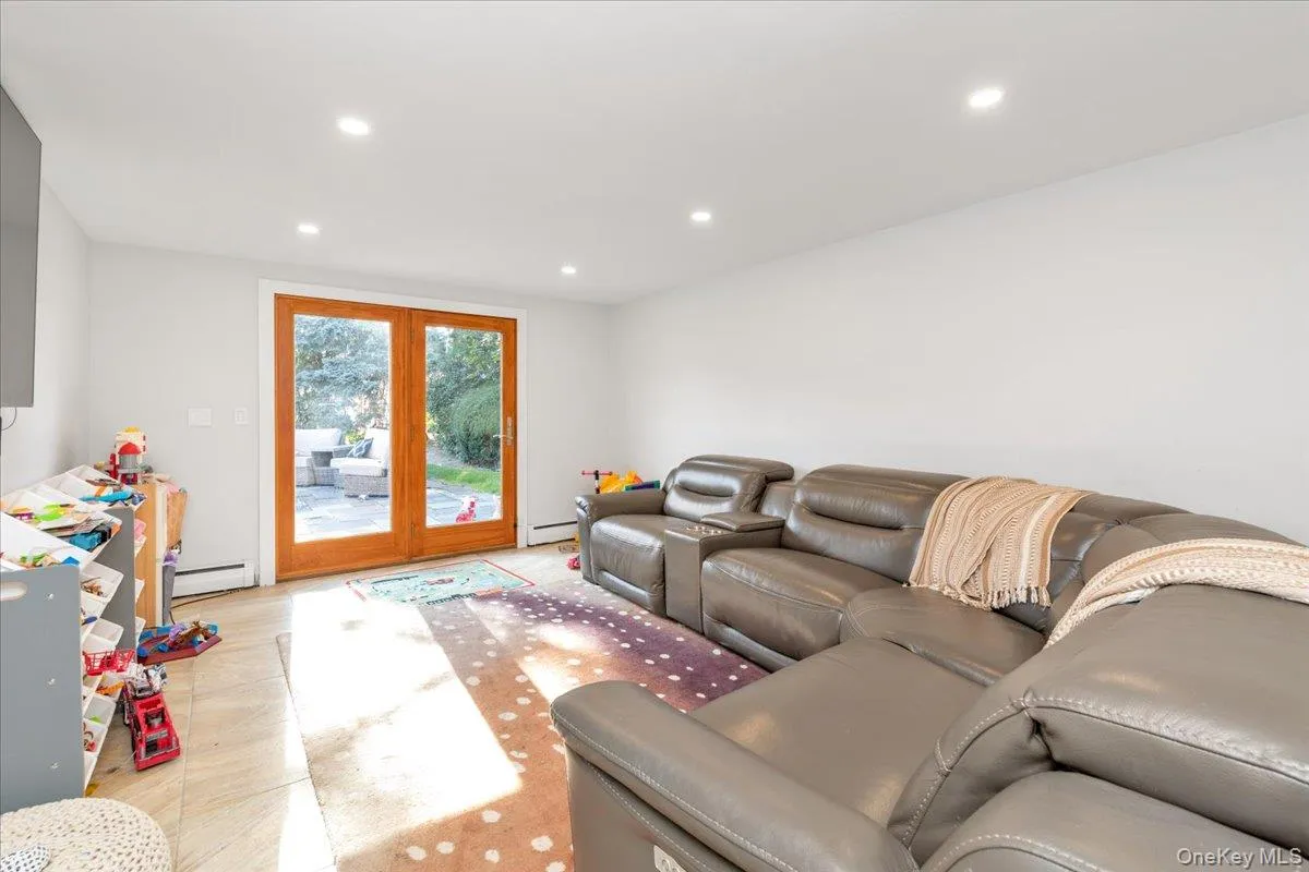 Living room with recessed lighting, a baseboard heating unit, and a baseboard radiator Living room with recessed lighting, a baseboard heating unit, and a baseboard radiator