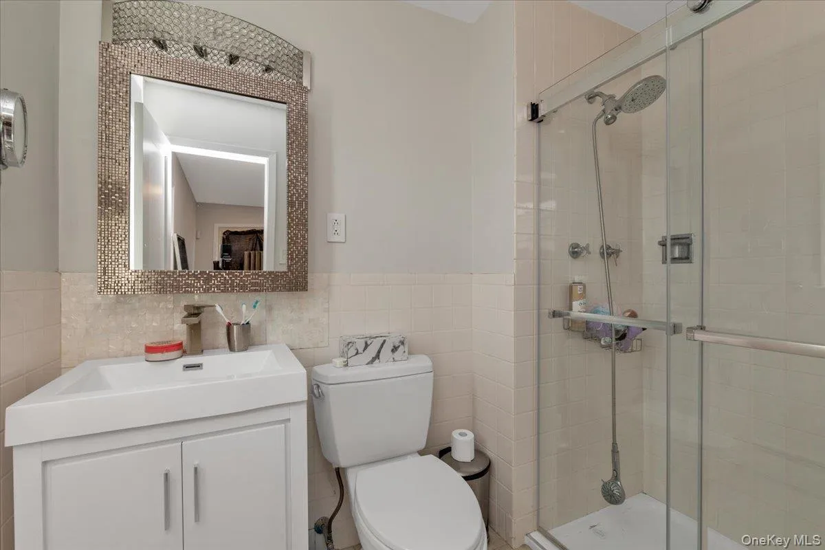 Full bath with tile walls, vanity, and a stall shower Full bath with tile walls, vanity, and a stall shower