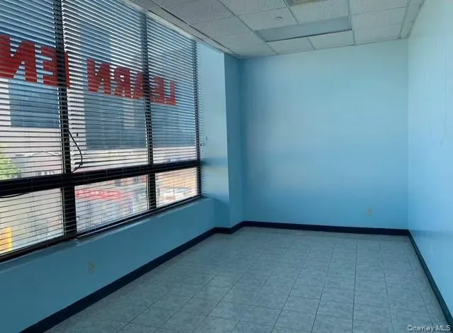 Unfurnished room featuring baseboards and a drop ceiling Unfurnished room featuring baseboards and a drop ceiling