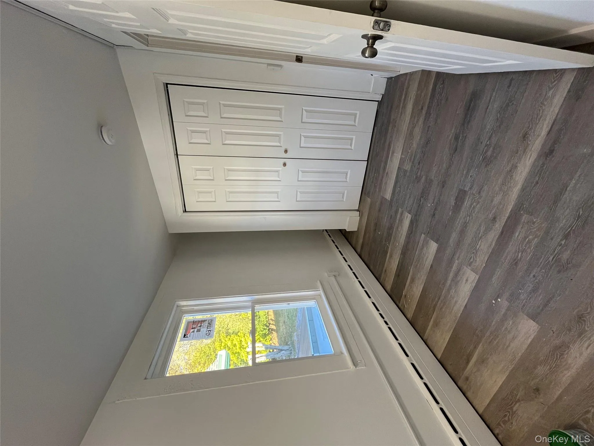 Unfurnished bedroom featuring a baseboard heating unit, dark wood-style flooring, and a closet Unfurnished bedroom featuring a baseboard heating unit, dark wood-style flooring, and a closet