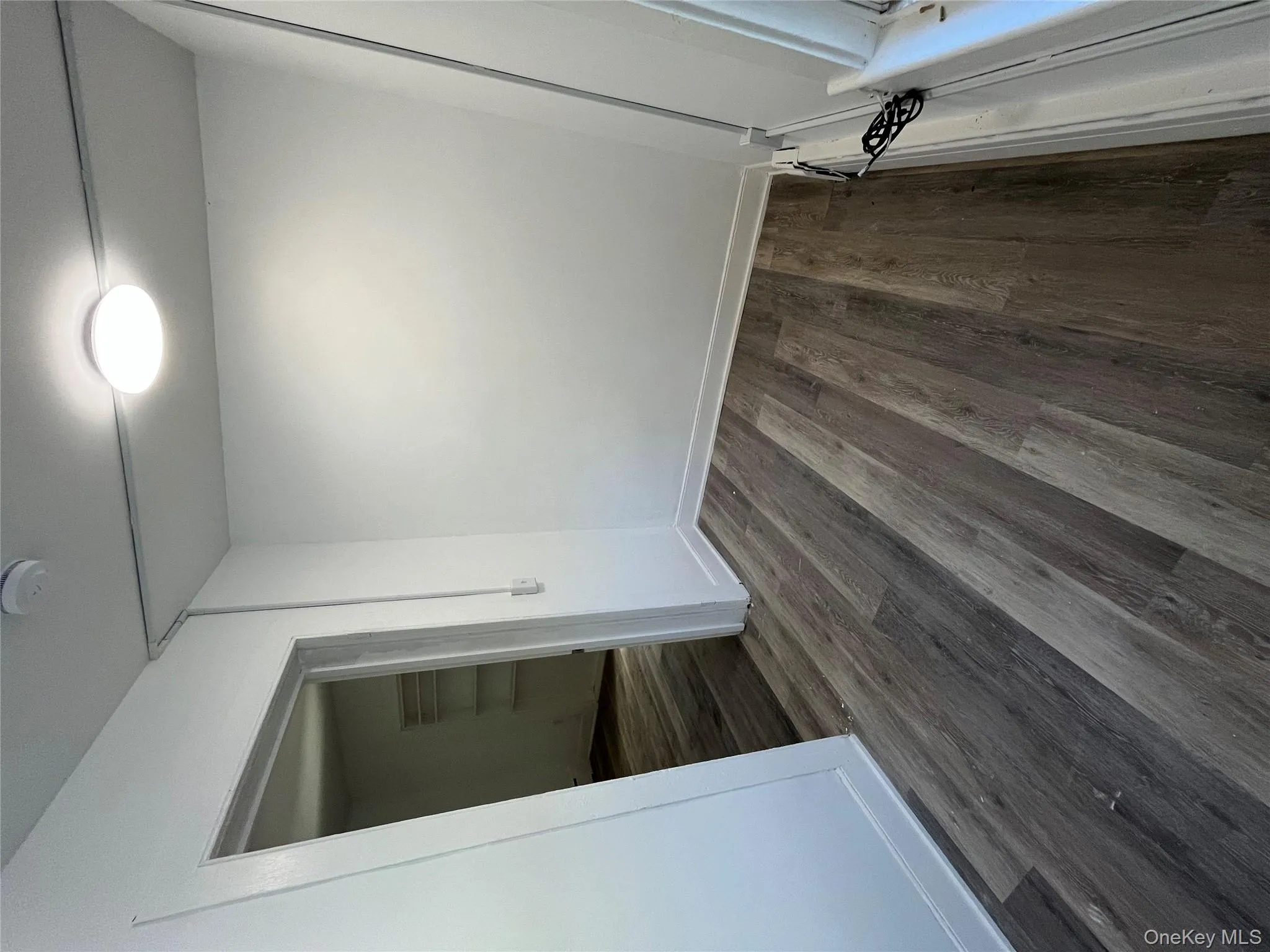Spare room with dark wood-type flooring and a smoke detector Spare room with dark wood-type flooring and a smoke detector