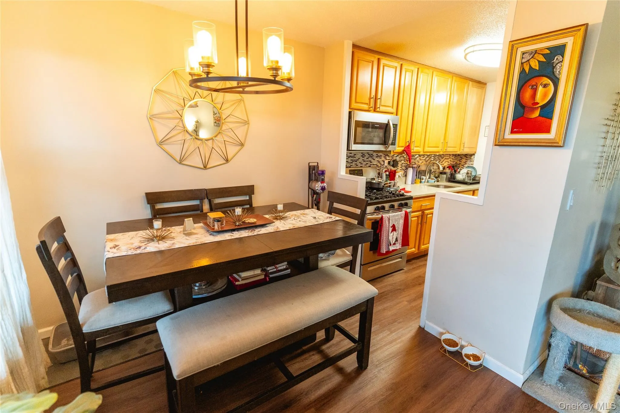 Dining area featuring dark wood-type flooring and a chandelier Dining area featuring dark wood-type flooring and a chandelier