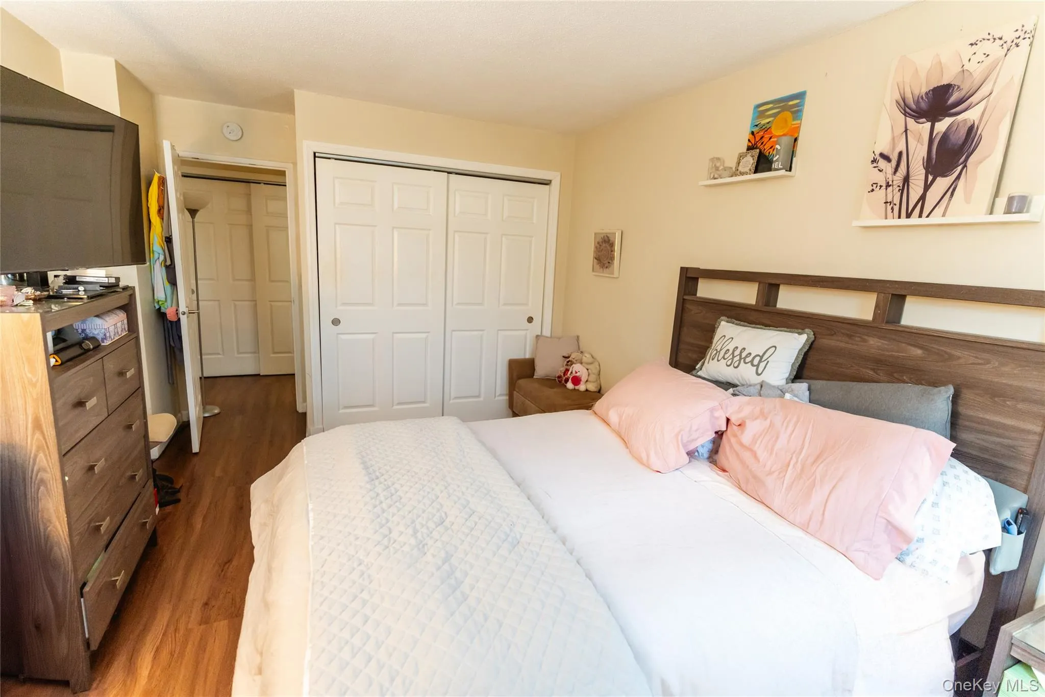 Bedroom featuring wood finished floors and a closet Bedroom featuring wood finished floors and a closet