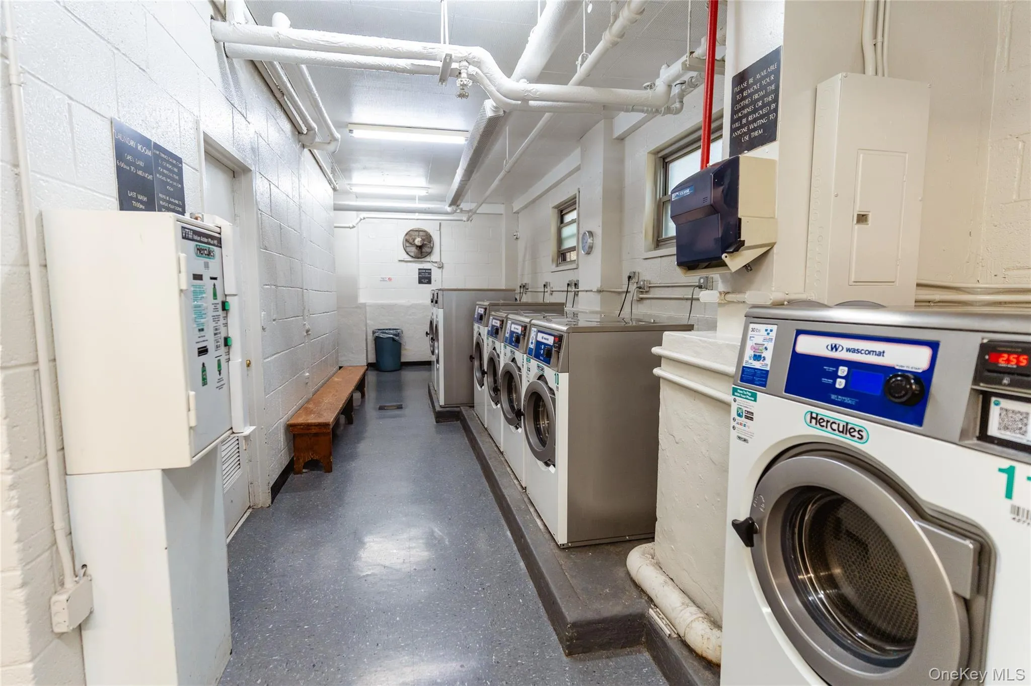 Community laundry room with electric panel and washing machine and clothes dryer Community laundry room with electric panel and washing machine and clothes dryer
