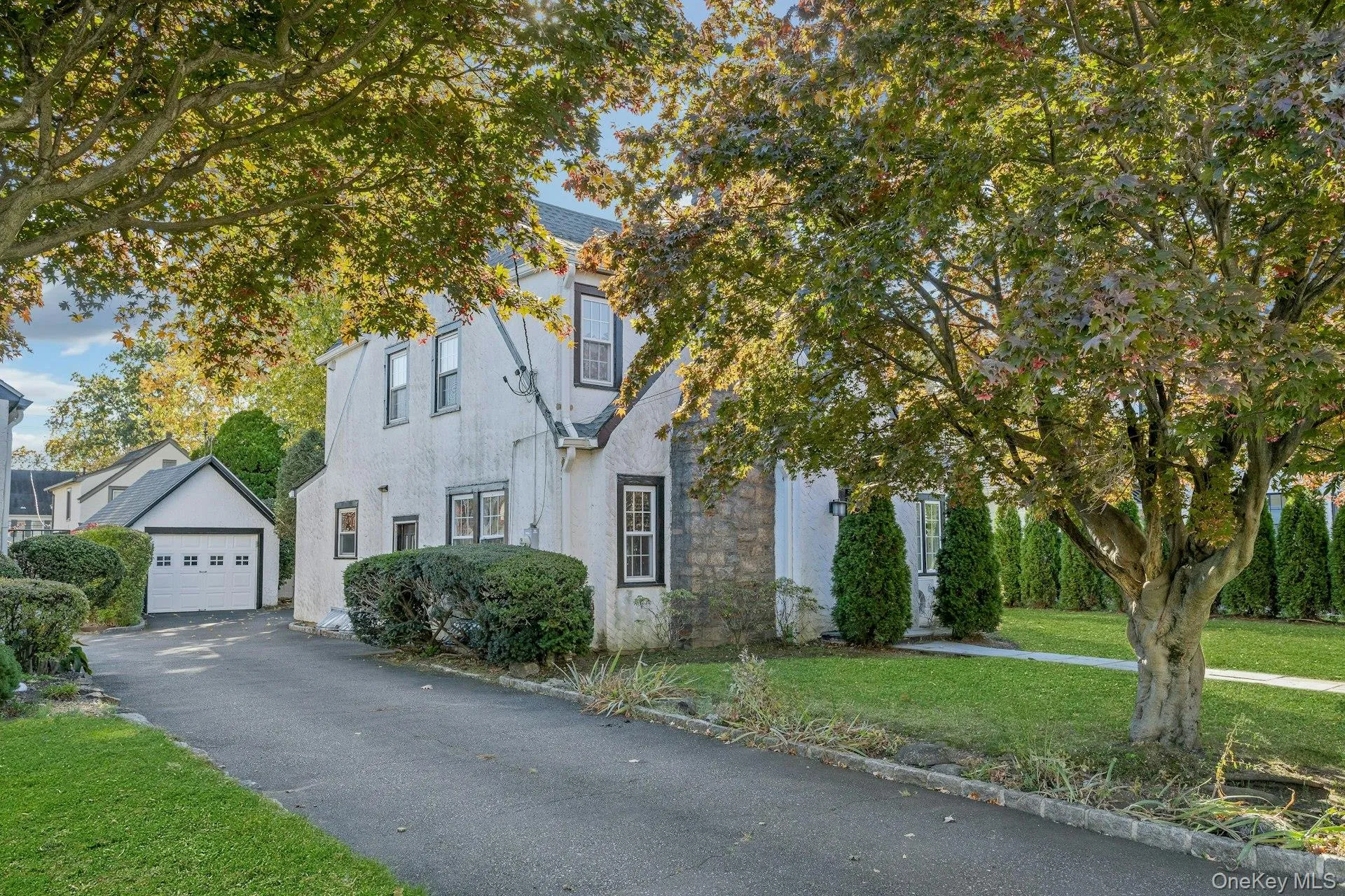 View of front of house featuring a front yard, stucco siding, a driveway to garage. View of front of house featuring a front yard, stucco siding, a driveway to garage.