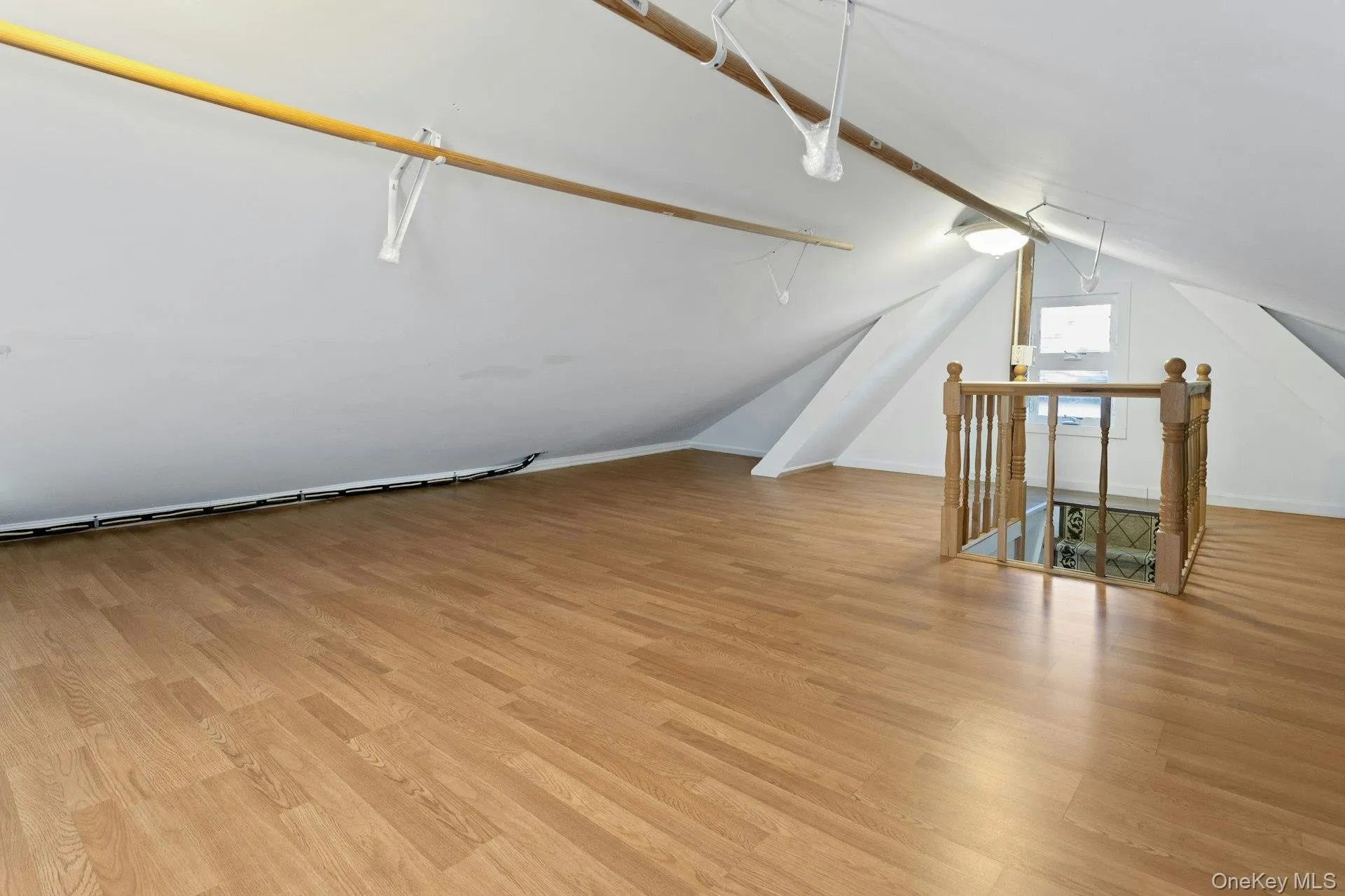 Additional living space featuring light wood finished floors and vaulted ceiling Additional living space featuring light wood finished floors and vaulted ceiling