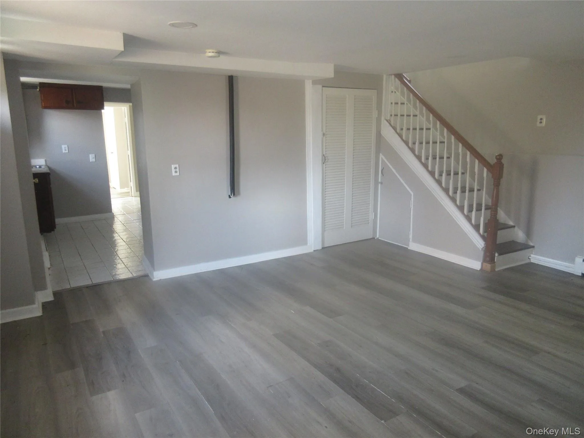 Unfurnished living room with dark wood finished floors and stairs Unfurnished living room with dark wood finished floors and stairs