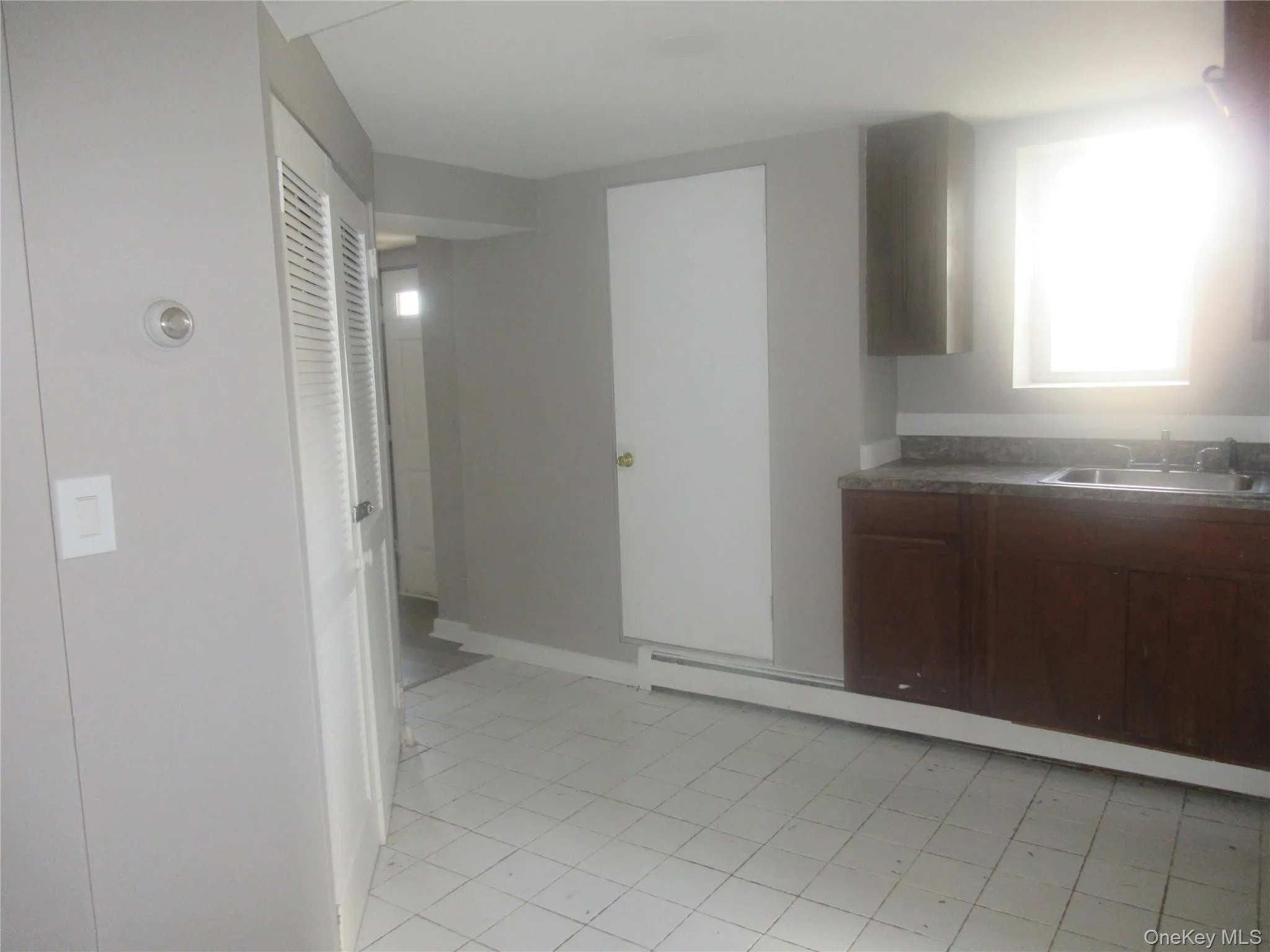 Kitchen with a sink and light tile patterned floors Kitchen with a sink and light tile patterned floors