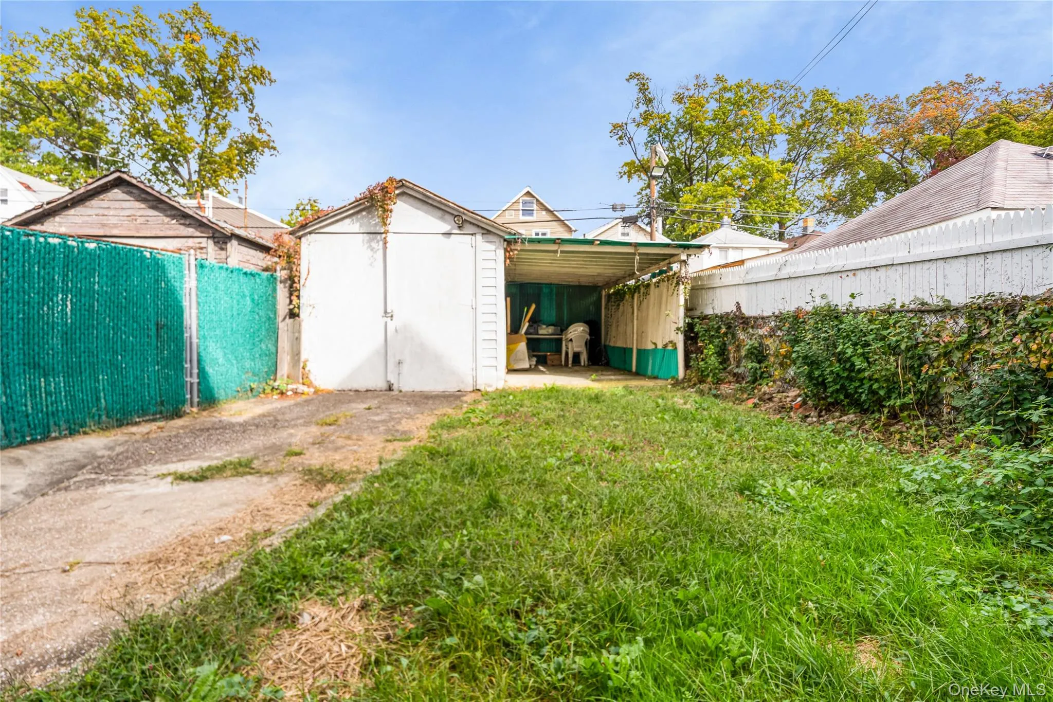 Fenced backyard with a patio area and a storage shed Fenced backyard with a patio area and a storage shed