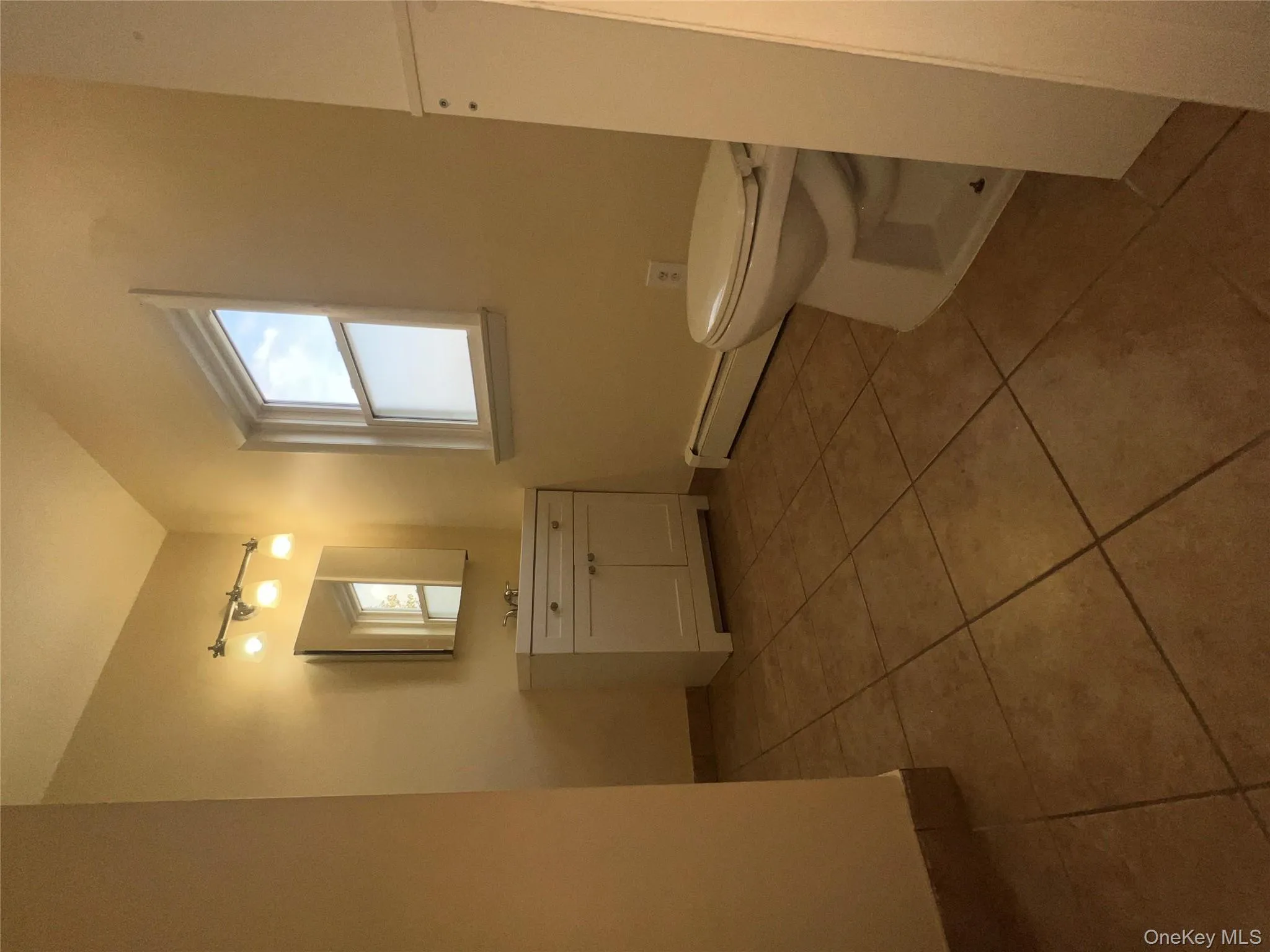 Bathroom with vanity, light tile patterned floors, and a baseboard radiator Bathroom with vanity, light tile patterned floors, and a baseboard radiator
