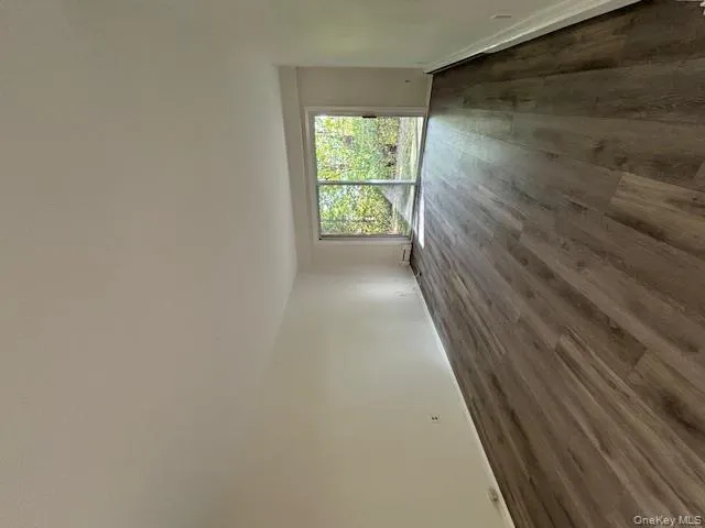 Spare room featuring dark wood-style floors and a baseboard heating unit Spare room featuring dark wood-style floors and a baseboard heating unit
