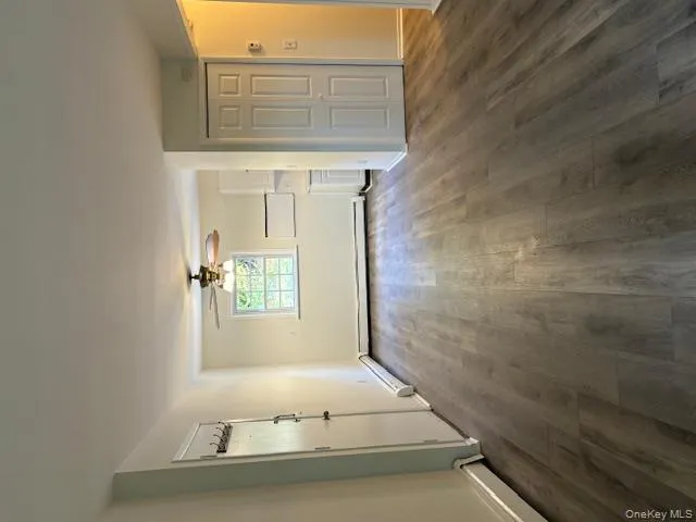 Unfurnished living room with dark wood-style flooring, a ceiling fan, and a baseboard radiator Unfurnished living room with dark wood-style flooring, a ceiling fan, and a baseboard radiator