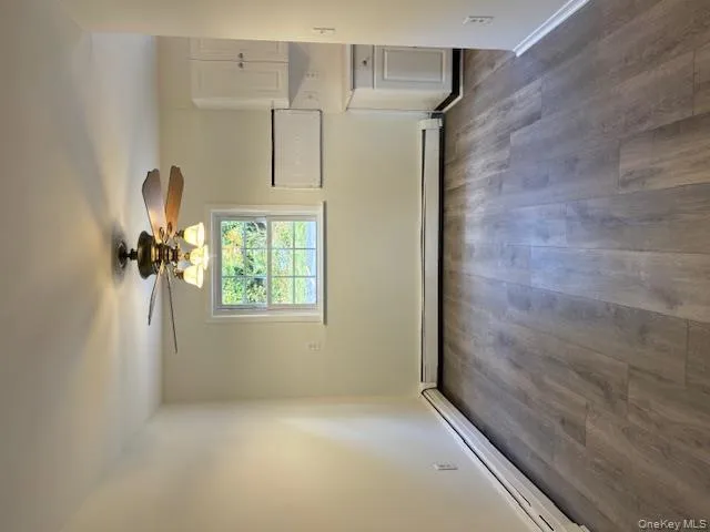 Unfurnished dining area with a baseboard radiator, dark wood finished floors, and a ceiling fan Unfurnished dining area with a baseboard radiator, dark wood finished floors, and a ceiling fan