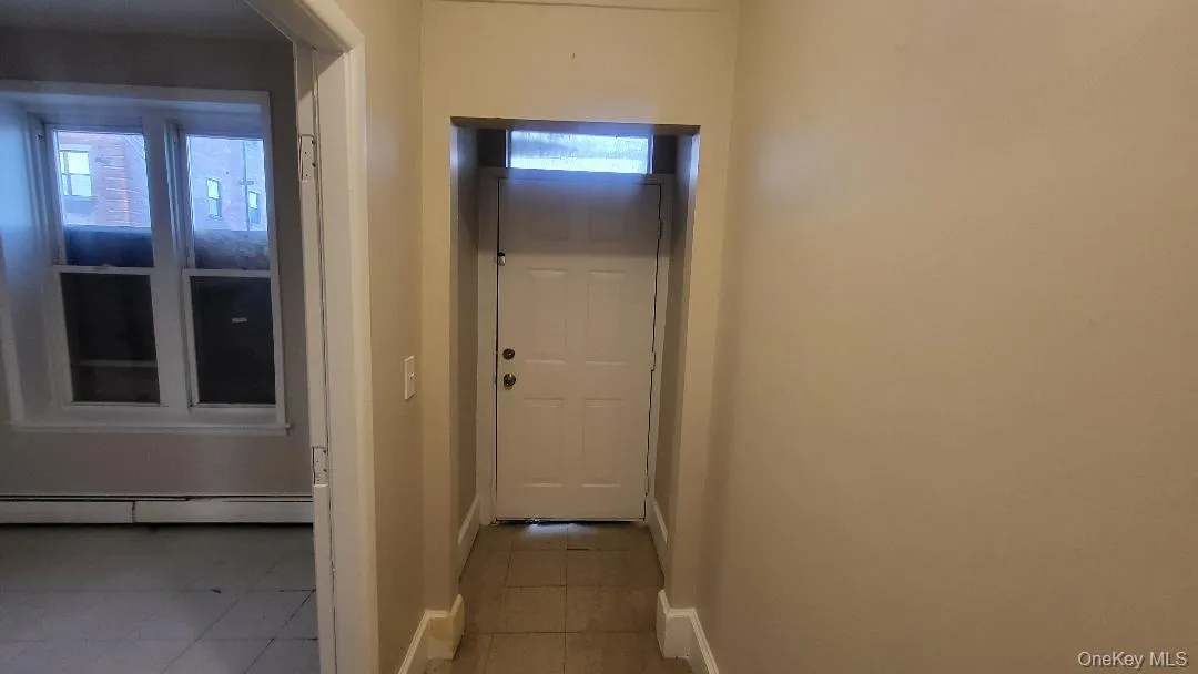 Entryway featuring tile patterned flooring and a baseboard heating unit Entryway featuring tile patterned flooring and a baseboard heating unit