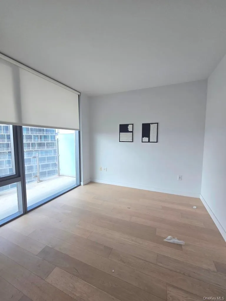 Spare room with floor to ceiling windows and light wood-style floors Spare room with floor to ceiling windows and light wood-style floors