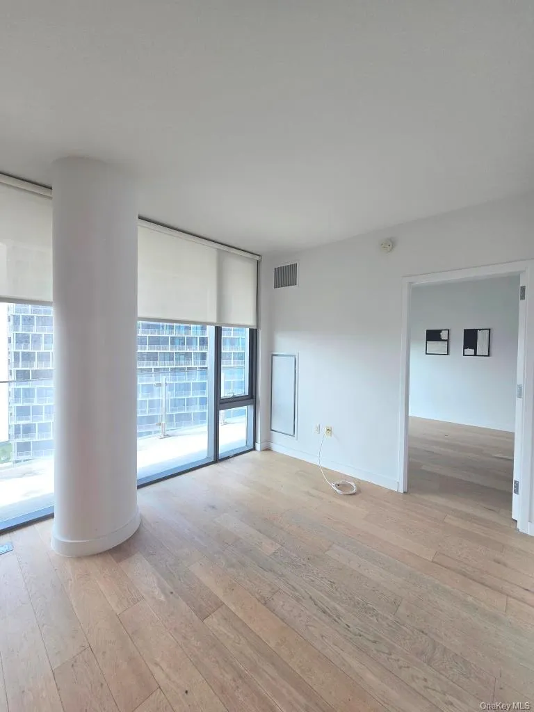 Empty room featuring expansive windows and light wood-style floors Empty room featuring expansive windows and light wood-style floors