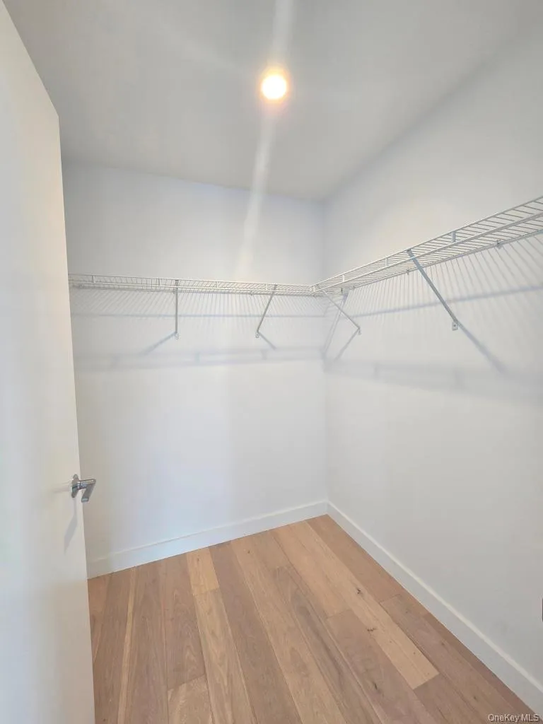 Walk in closet featuring light wood finished floors Walk in closet featuring light wood finished floors