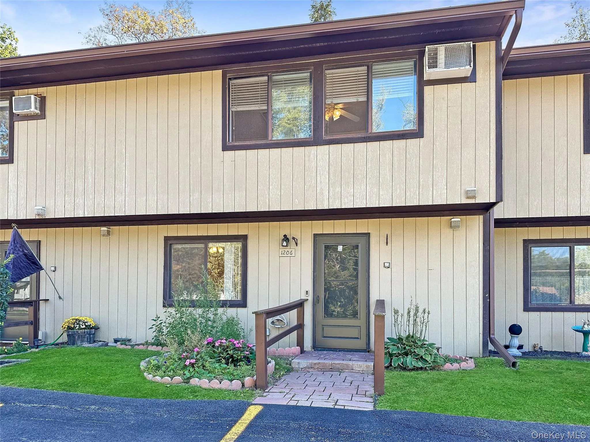 View of front of house with a front lawn and a wall mounted air conditioner View of front of house with a front lawn and a wall mounted air conditioner