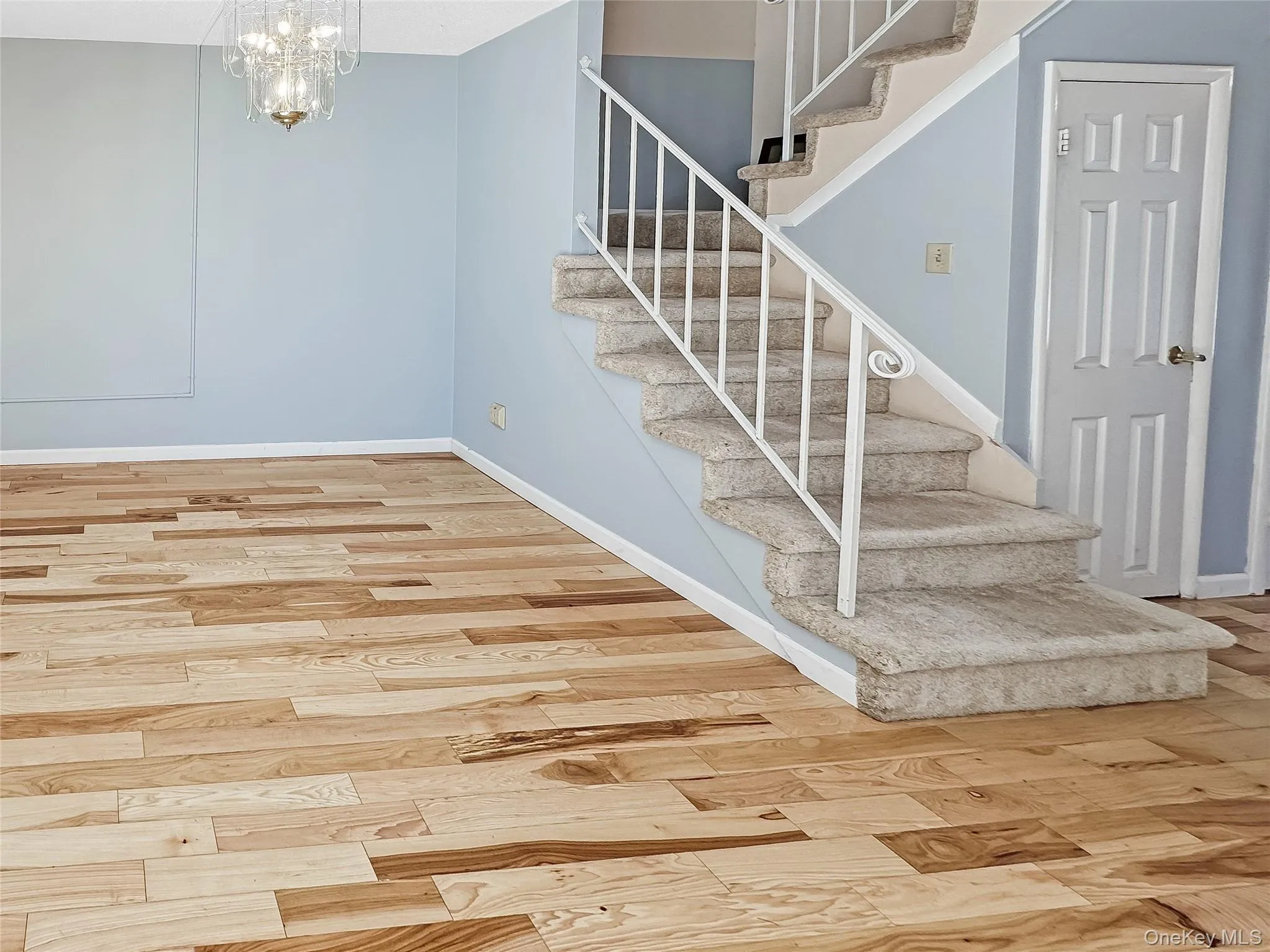 Stairway featuring wood finished floors and a chandelier Stairway featuring wood finished floors and a chandelier