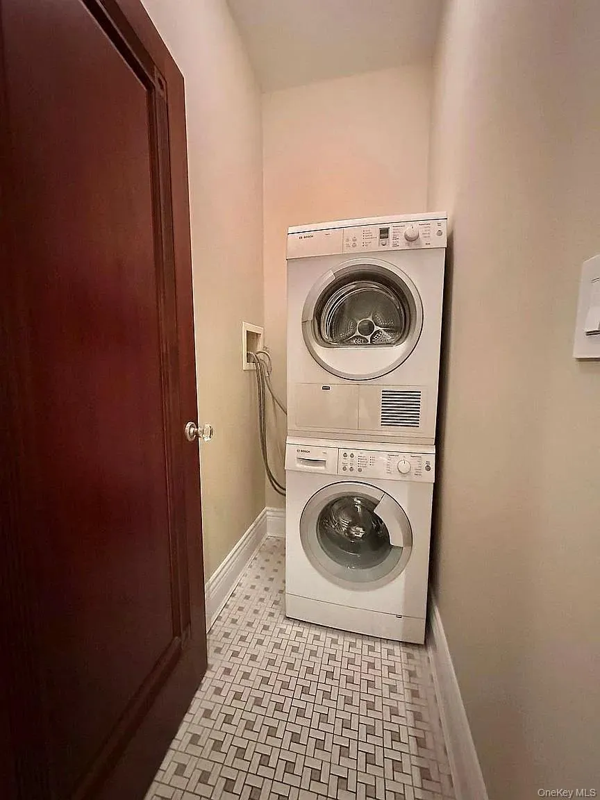 Laundry area with baseboards and estacked washer and dryer Laundry area with baseboards and estacked washer and dryer