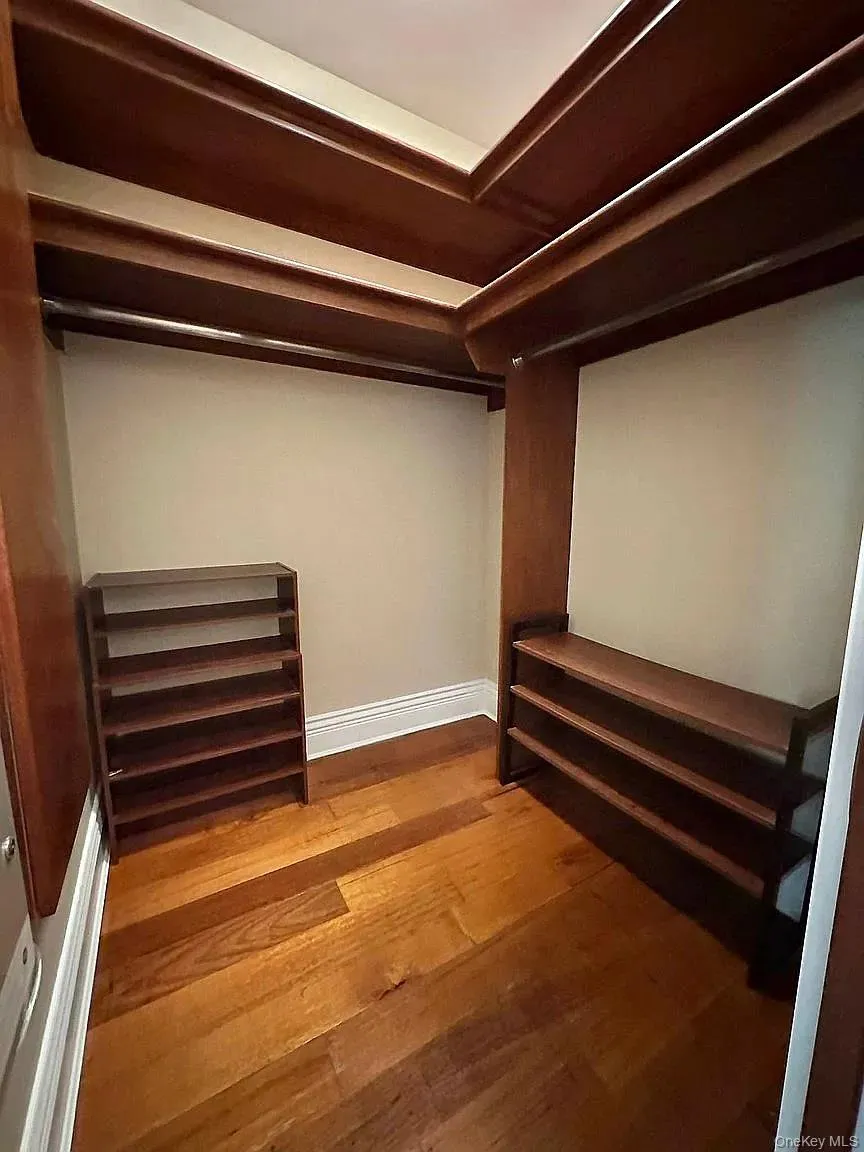 Walk in closet featuring hardwood / wood-style flooring Walk in closet featuring hardwood / wood-style flooring