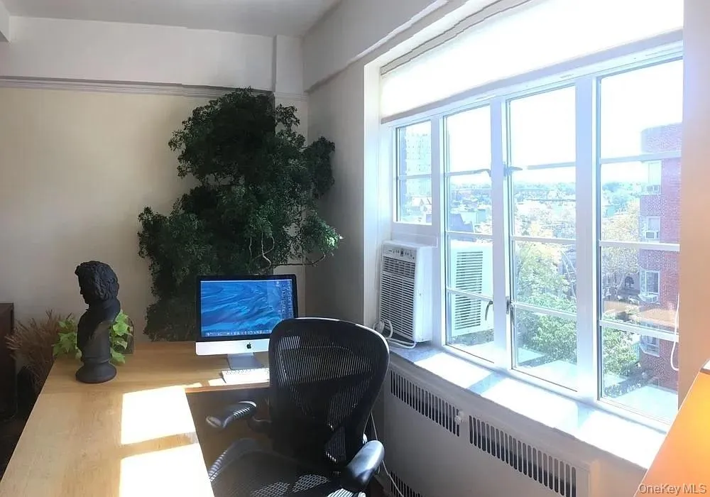 Home office featuring radiator heating unit and wood finished floors Home office featuring radiator heating unit and wood finished floors