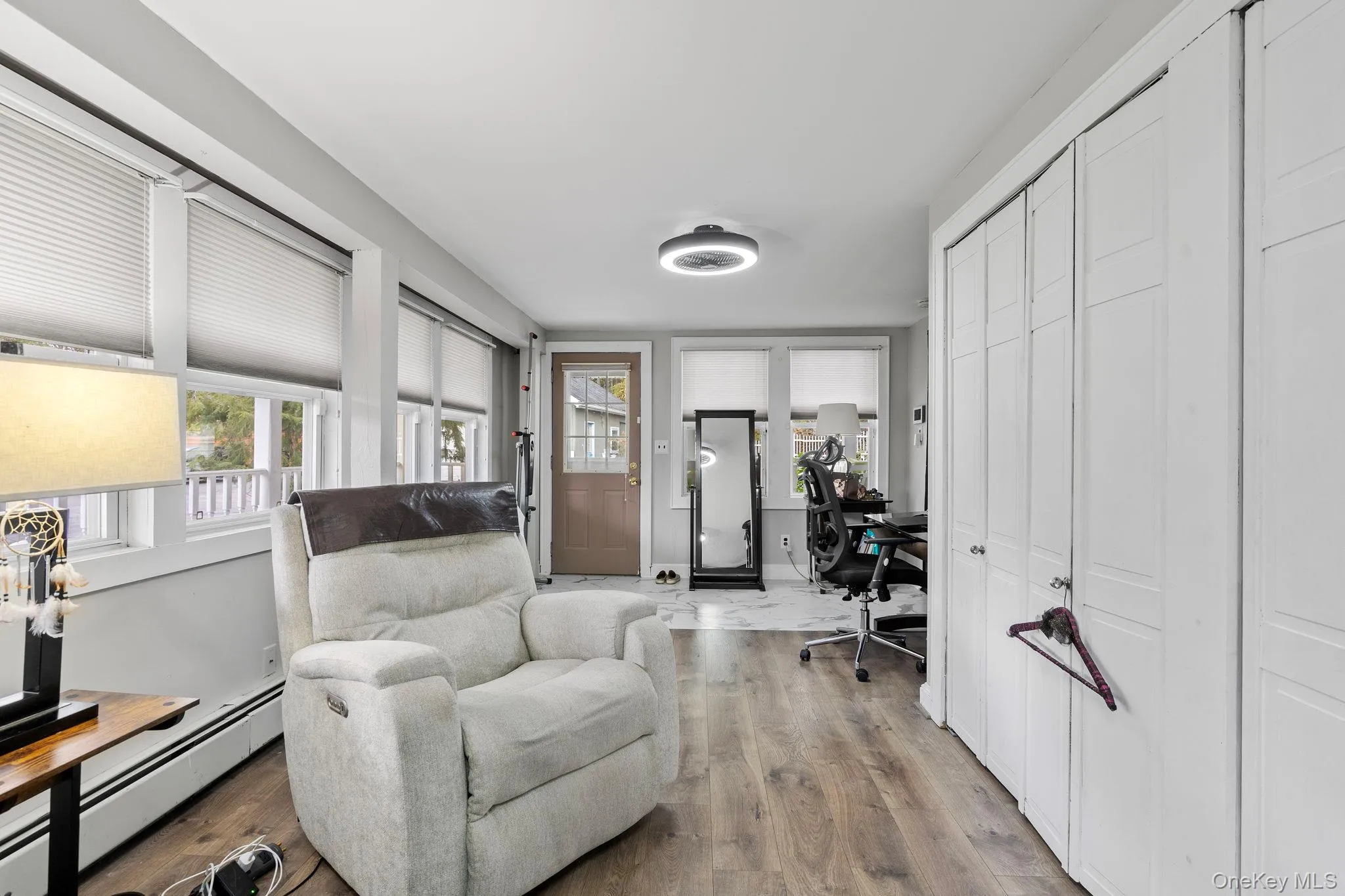 Home office featuring a baseboard heating unit and wood finished floors Home office featuring a baseboard heating unit and wood finished floors