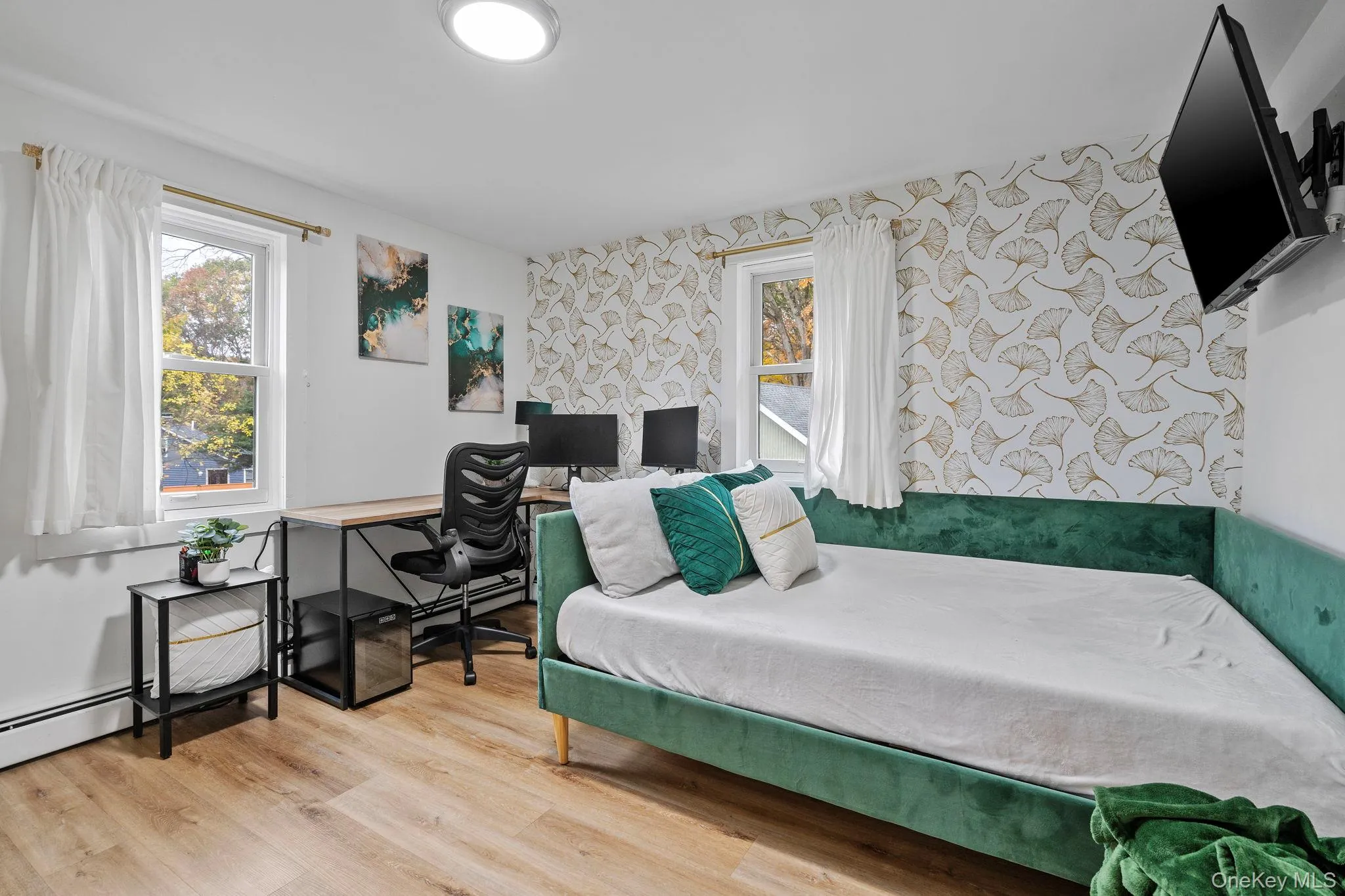 Bedroom with light wood-style floors, wallpapered walls, and a desk Bedroom with light wood-style floors, wallpapered walls, and a desk
