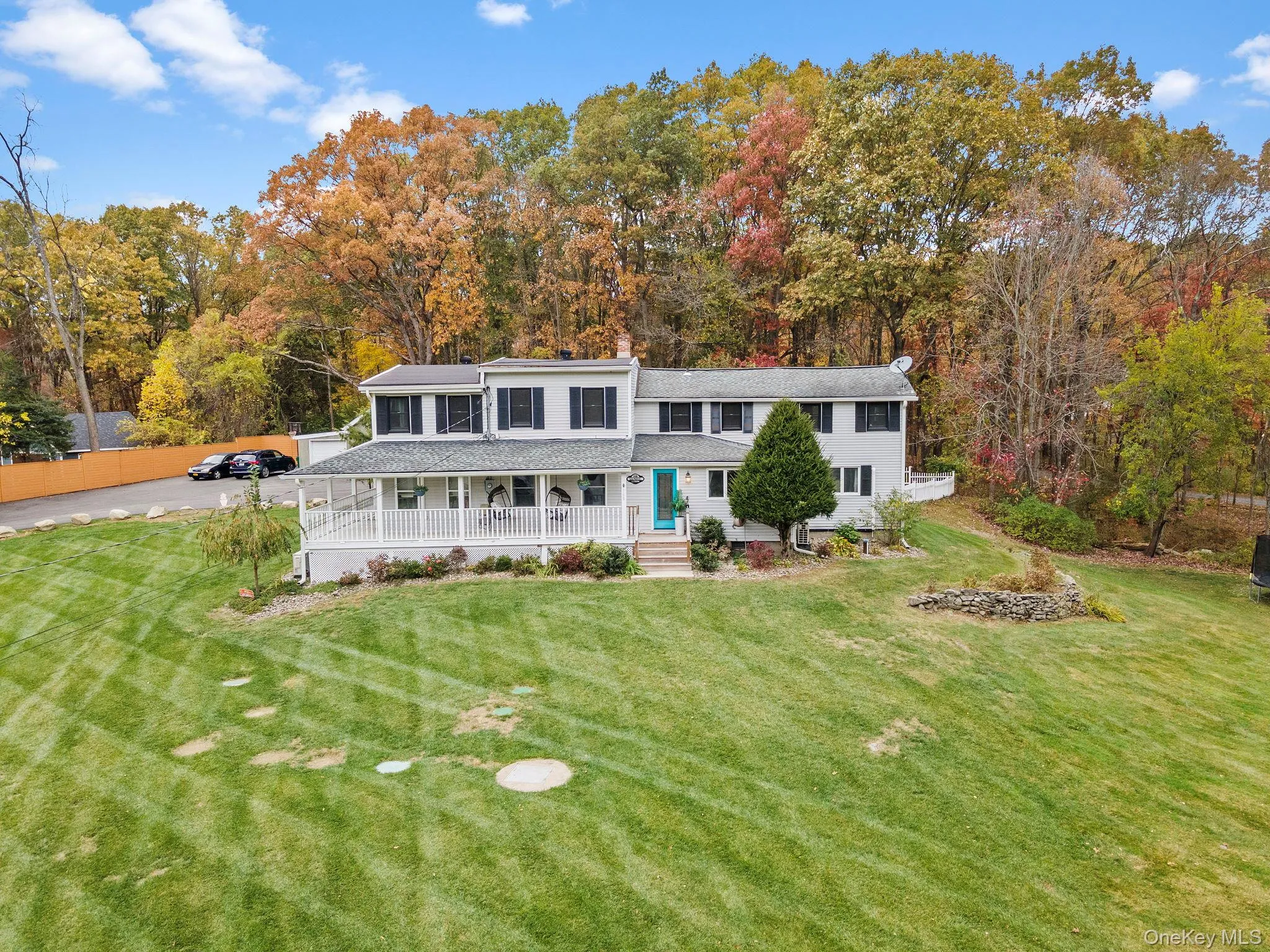 Back of property featuring a porch, a lawn, and a chimney Back of property featuring a porch, a lawn, and a chimney