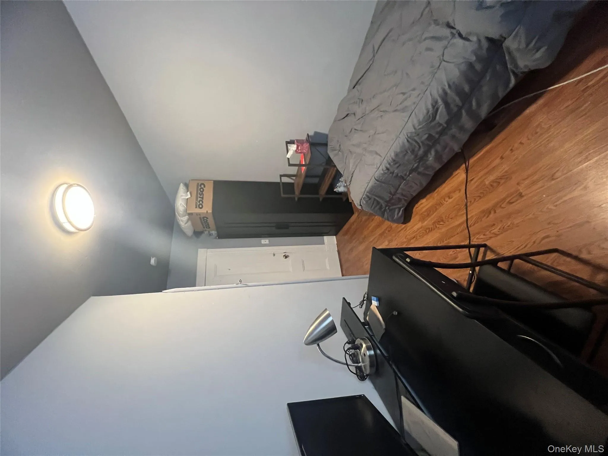 Bedroom with light wood-style flooring and an office area Bedroom with light wood-style flooring and an office area